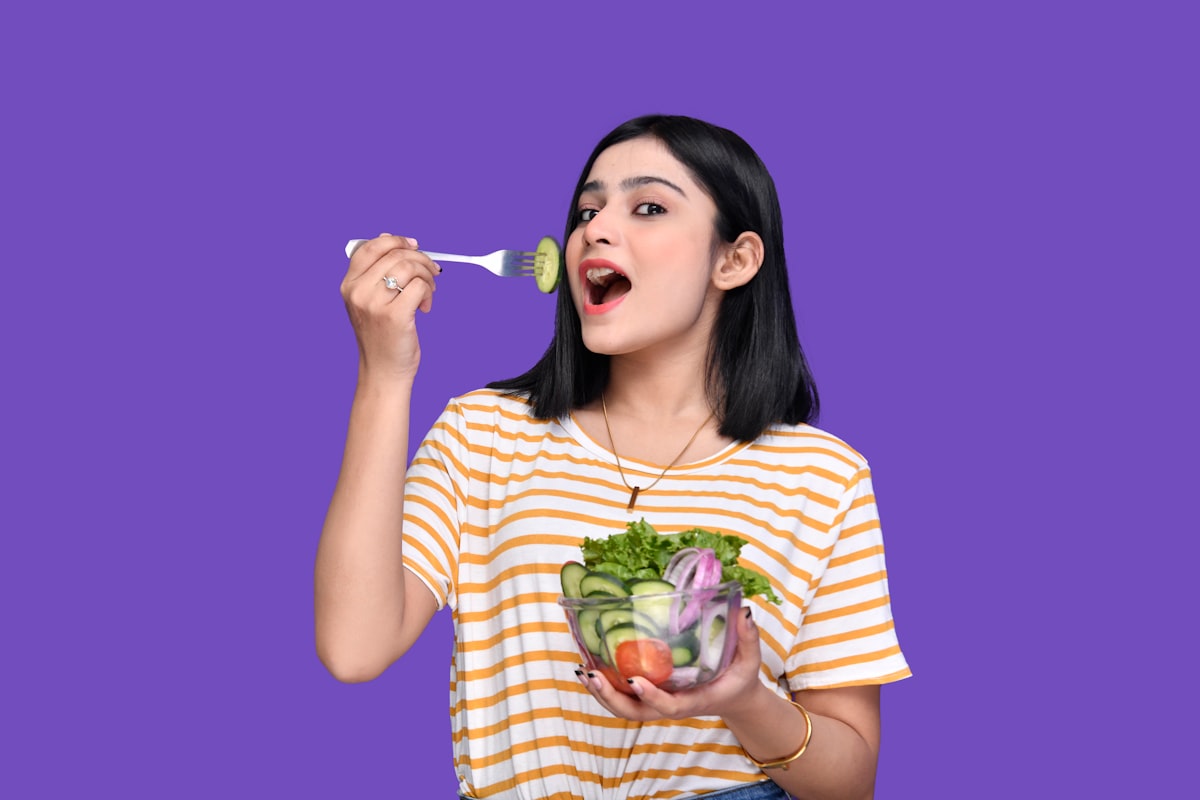 Woman enjoying healthy meal with fresh vegetables and fruits
